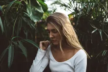 a sad woman surrounded by greenery