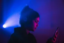 Woman wearing headphones and looking at phone