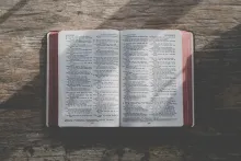 an open Bible on a wood table