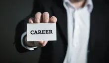 a man holding a business card that says "career"