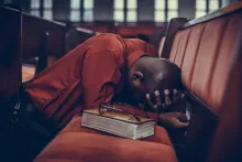 A man with his head down in prayer.