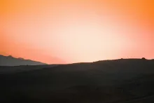 A sunset over a hill.