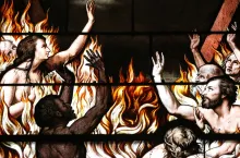 An artist rendition on stainglass of people burning in a fire.