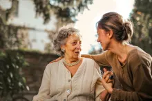 joyful adult daughter greeting happy surprised woman in garden