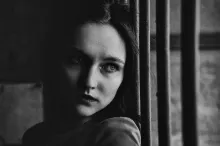 a woman leaning against a fence