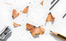 Pencil on white background with pencil shavings and sharpener