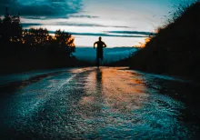 Silhouette photo of a person running on road.