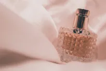 a glass bottle of perfume swathed in pink material
