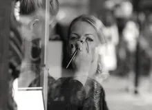 A woman getting makeup put on her in a salon.