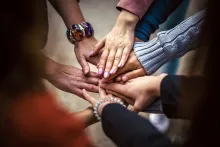 several hands extended to one another in a group