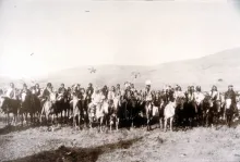 A large group of men on horseback with mountains in the background. In the front center of the group can be seen Chief Joseph, White Bird and Looking Glass.