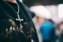 A person wearing a cross necklace.