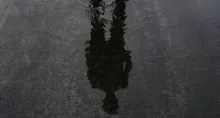 A person's shadow in shallow pool of water.