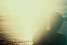 A silhouette of a woman holding a young child.
