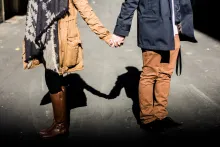 A young couple holding hands while walking.