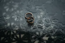 Two wedding rings lying a table.