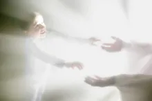 A photo illustration showing a person reaching for another person surrounded by bright lights.