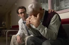 A doctor consoling a person who is grieving.