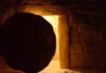 A round stone in front of a tomb entrance.