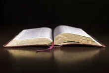 An open Bible laying on a table.