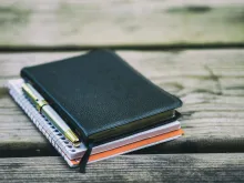 Bible, notebook and pen on a table.