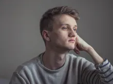 A young man resting his head on his hand.