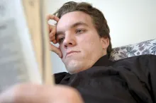 A worried looking man reading.