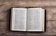 A Bible laying on a table opened to the book of Matthew.