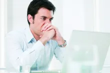 A man looking at his laptop screen.