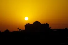 A sunset over a Muslim mosque.