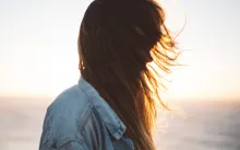 Sun rays shining through a young woman's hair.