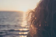 A young woman looking out over the ocean.