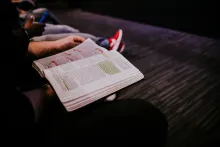 A young person reading a Bible.