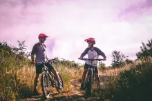 A dad and son riding mountain bikes.