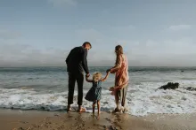 A family wading in the waves of the ocean.