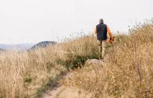 A man walking on a dirt trail.