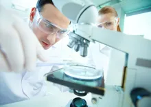 Scientist looking at a microscope.