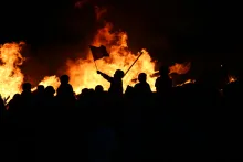 People at a riot burning items.
