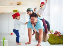 A dad playing with his kids.