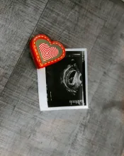 An ultrasound photo with a red heart next to it