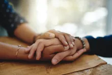 Comforting hands of two people.