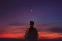 A person looking at the horizon of a sunrise.