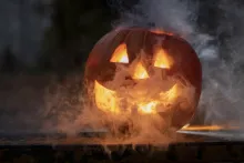 a jack-o-lantern that is glowing with smoke coming out from inside
