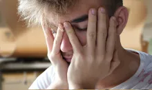 a young man with his head in his hands