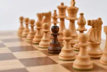 one different-colored pawn amongst a row on a chessboard