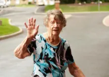 An elderly woman waving.