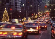 A busy city street lined with Christmas decorations and lit trees.