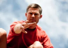 A man reaching out his hand to help pull someone up.