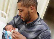 A new dad holding his baby.