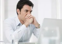 A man looking at his laptop screen.